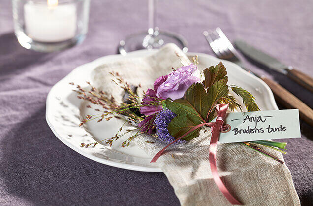 Her har vi laget et blomstersmykke til hver gjest, og merket det med navn og relasjon til den som feires. Her har vi laget et blomstersmykke til hver gjest, og merket det med navn og relasjon til den som feires.